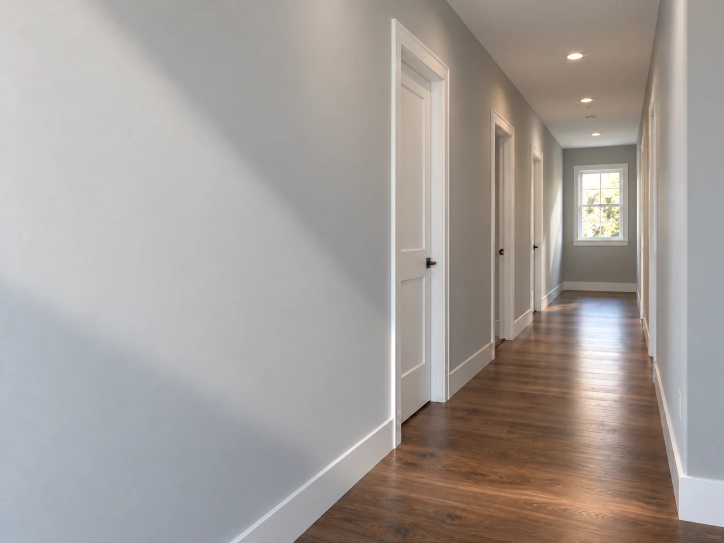 Smooth painted walls and ceiling in a sunlit residential hallway.
